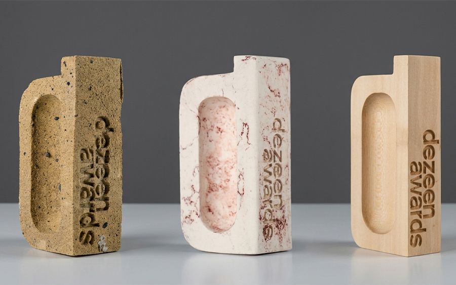 Trois versions du trophée des Dezeen Awards : argile, bois et micropapier marbré